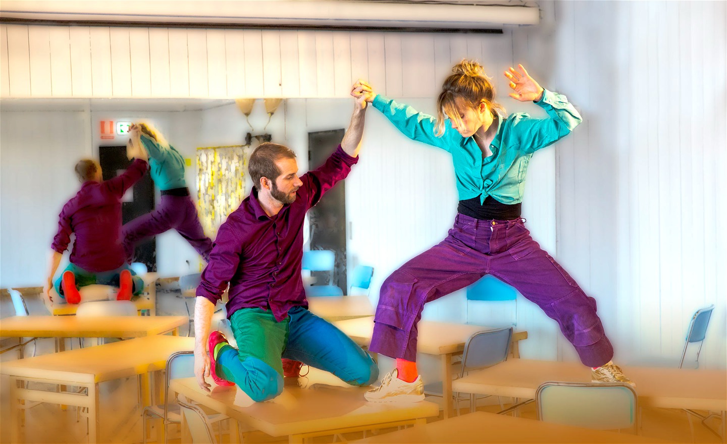 En kvinnlig och manlig dansare som dansar på skolbänkarna i klassrummet