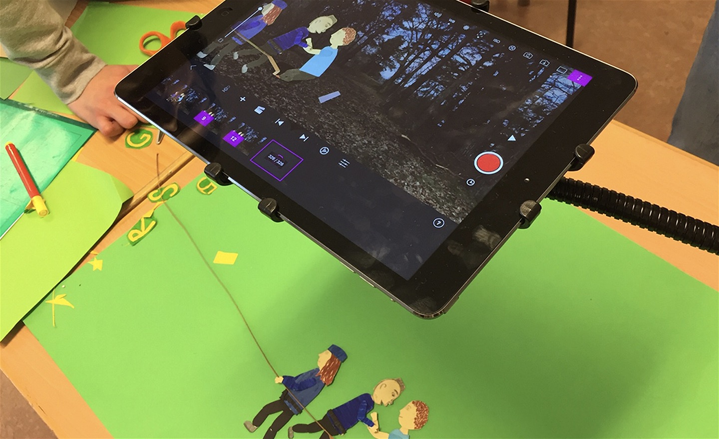 Tre figurer utklippta i papper animeras med en iPad mot en greenscreen
