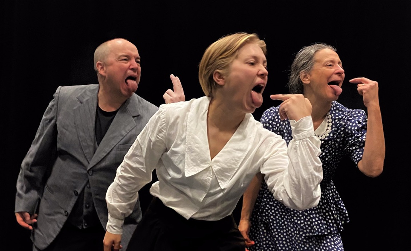 Tre dansare, i kläder som för tankarna till 1930-talet, gapar stort och räcker ut sina tungor. 