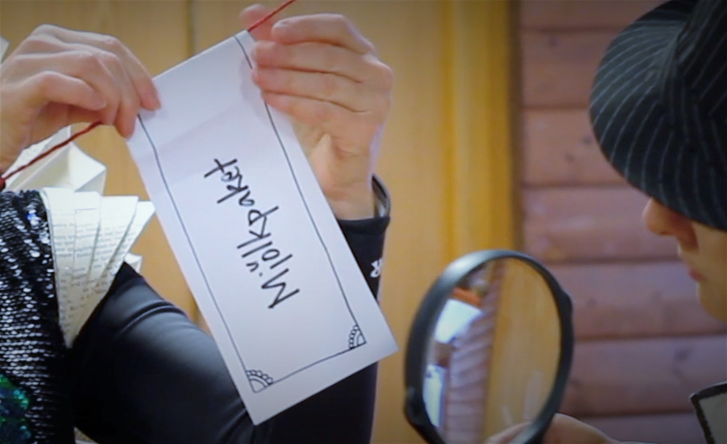 Två personer hänger upp en lapp med ordet 