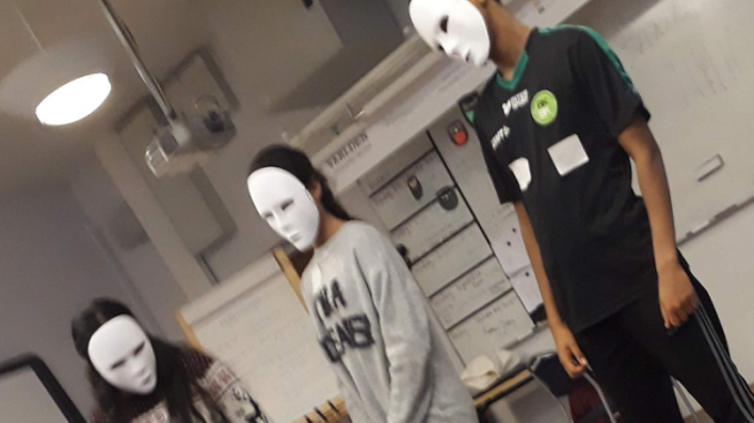 Tre personer med vita ansiktsmasker.
