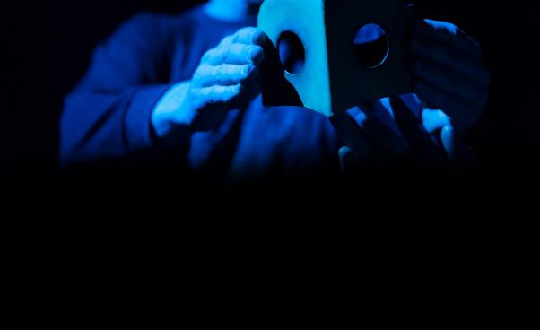 Ett par händer håller i en mask.