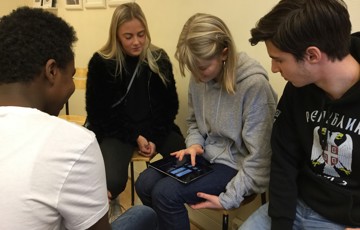 Fyra elever sitter tillsammans och redigerar film på en Ipad.