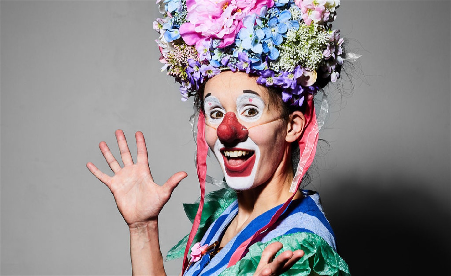 Clown med blomkrona på huvudet.