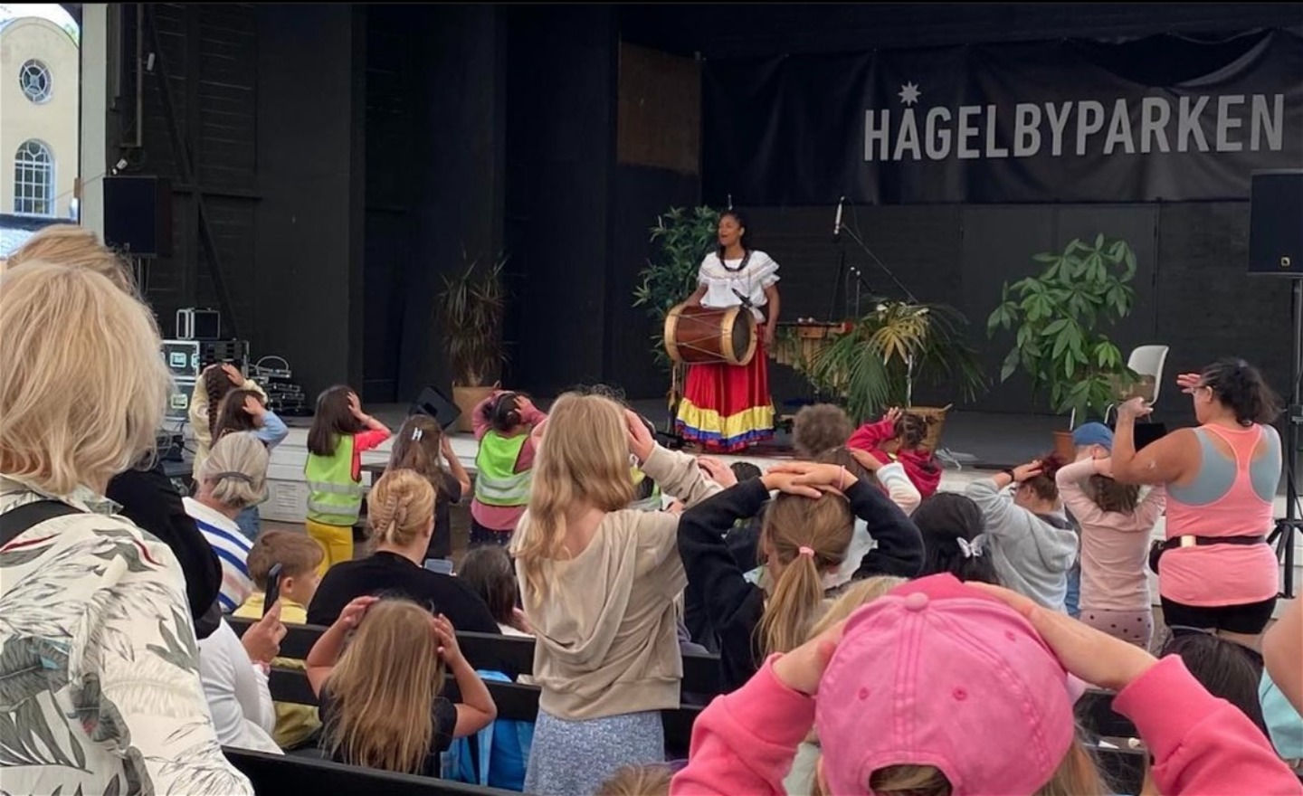 Diva Cruz uppträder på scen framför en publik i Hågelbyparken.