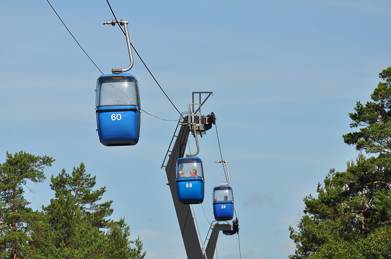 en linbana med tre blåa gondoler.