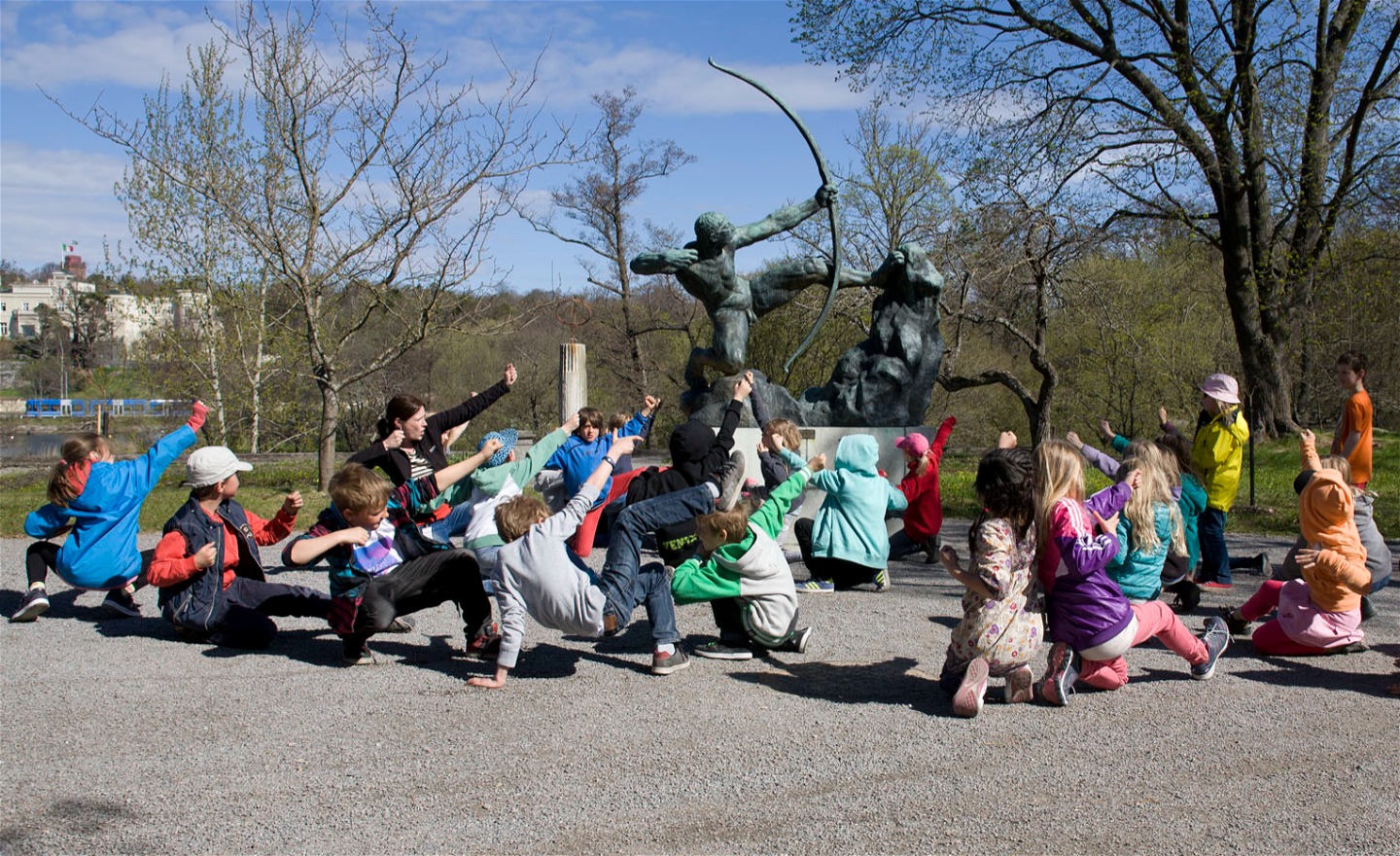 Fotografi av en skolklass som härmar skulpturen Herakles