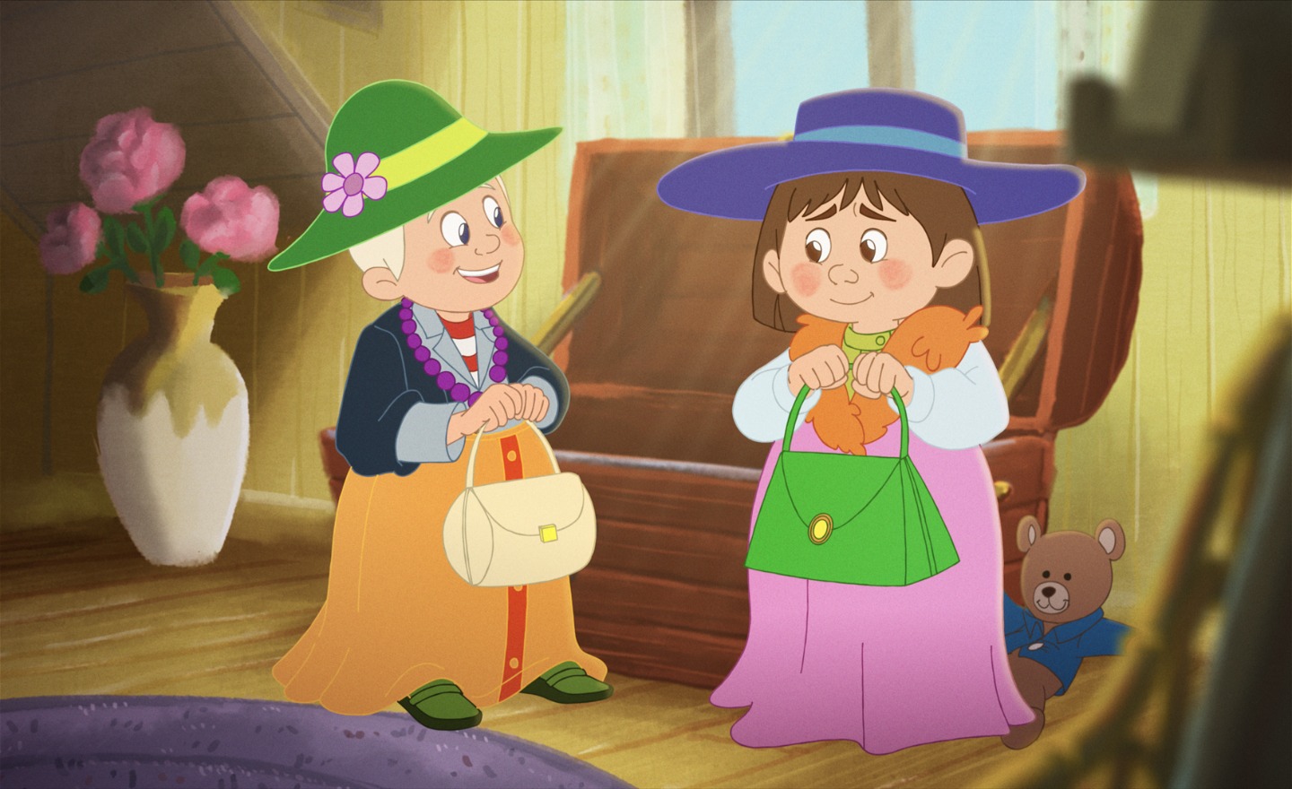 Två lekande barn har klätt ut sig i långa klänningar, hatt och handväska. Bredvid dem sitt en nalle i blå kofta.