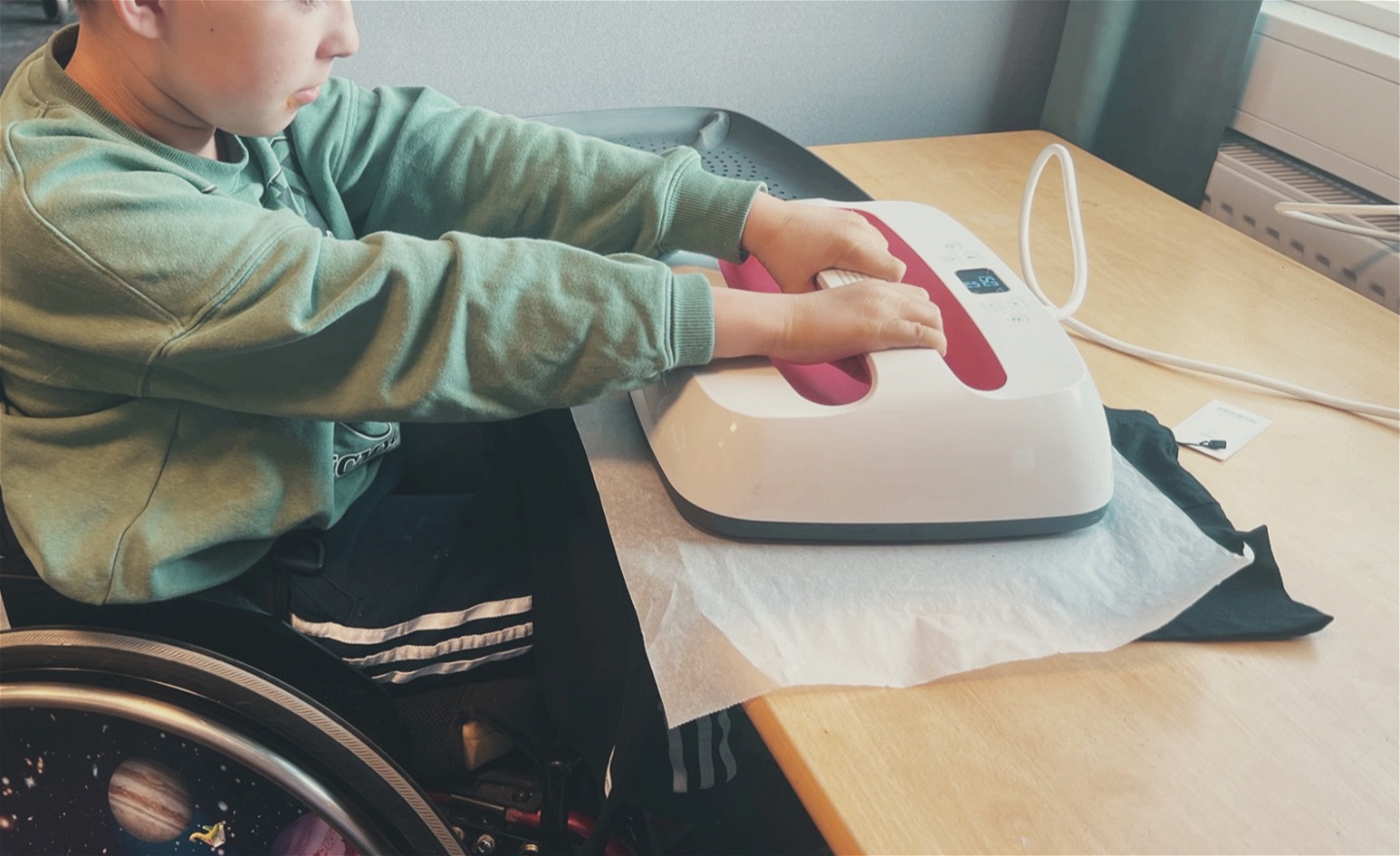 En elev använder transferpressen för att trycka sin t-shirt.