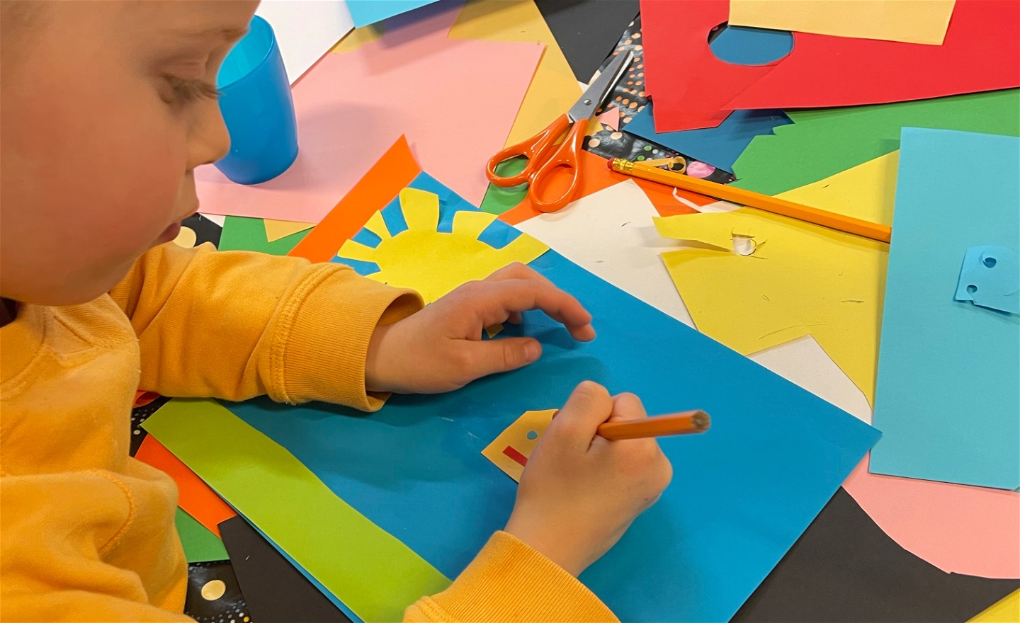 Foto som visar barn som skapar ett färgglatt papperscollage.