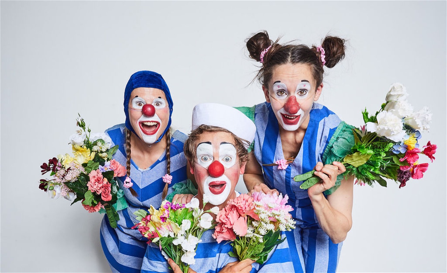 Tre clowner med varsin blombukett.