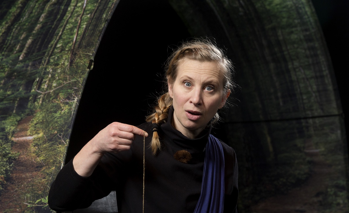 Bilden föreställer skådespelare som berättar och håller upp ett smycke.