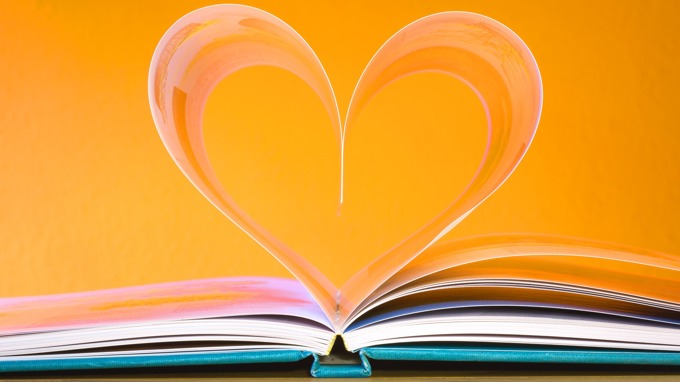En uppslagen bok där två sidor formar ett hjärta.