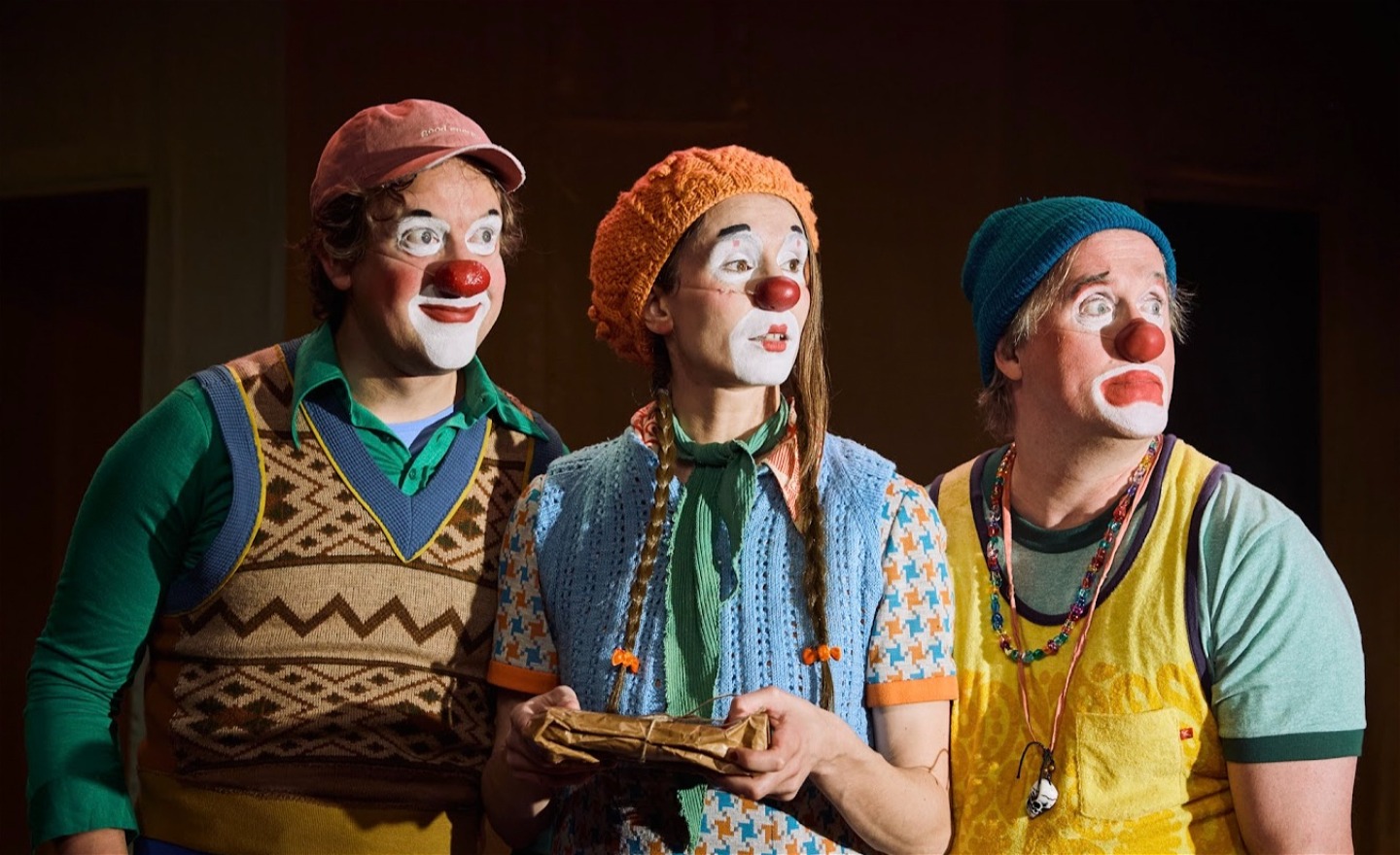 Tre clowner tittar ut åt höger