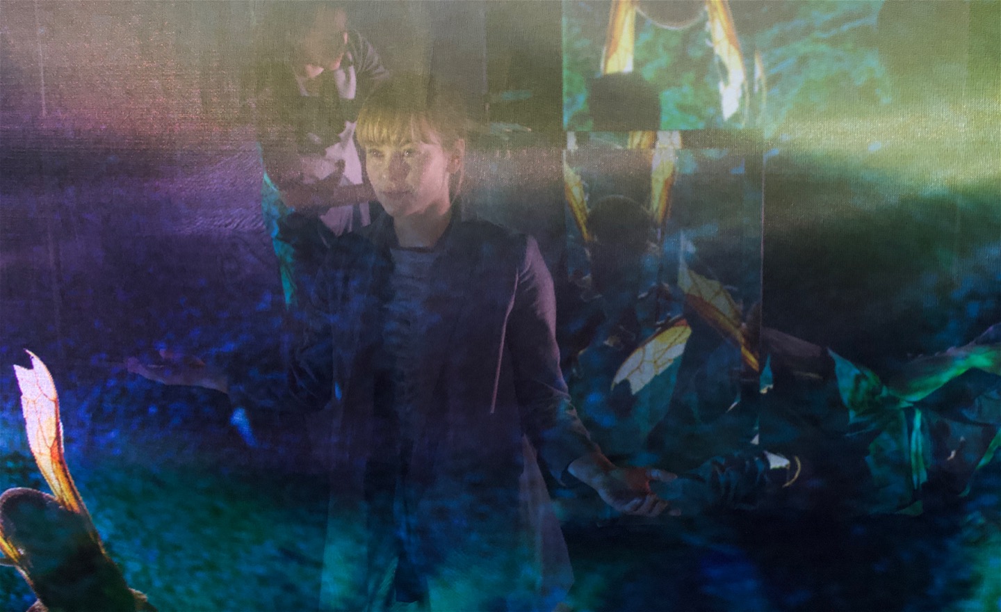 Dansare bakom en grönskimrande nätskärm