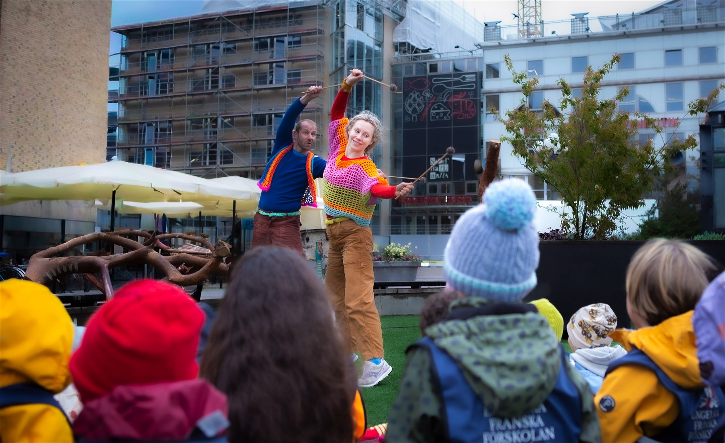 en utomhusföreställning där två dansare dansar för förskolebarn