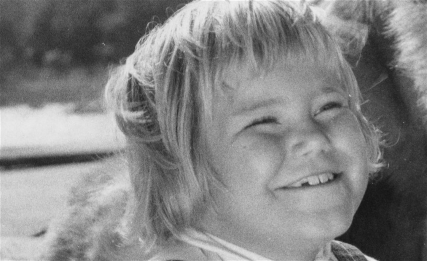 Flickan Tjorven tittar snett uppåt och ser glad ut.