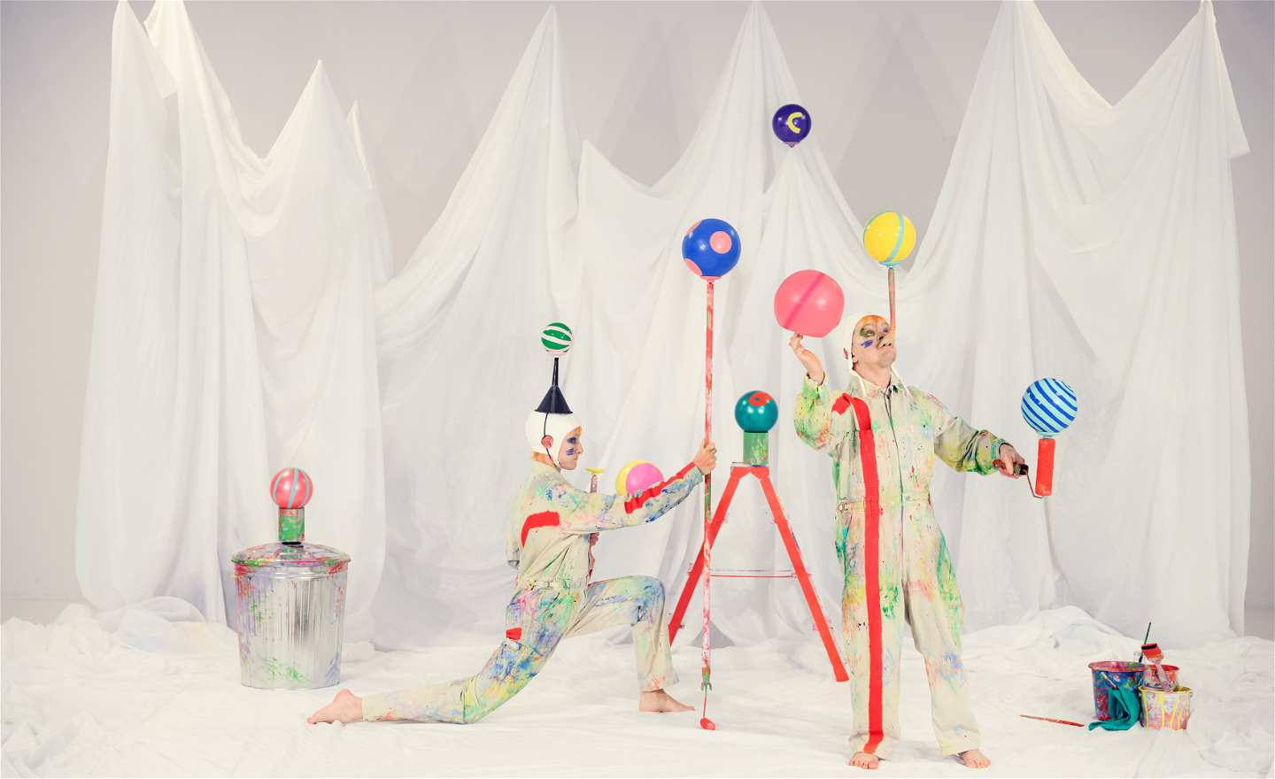 Två clowner jonglerar med bollar och bokstäver