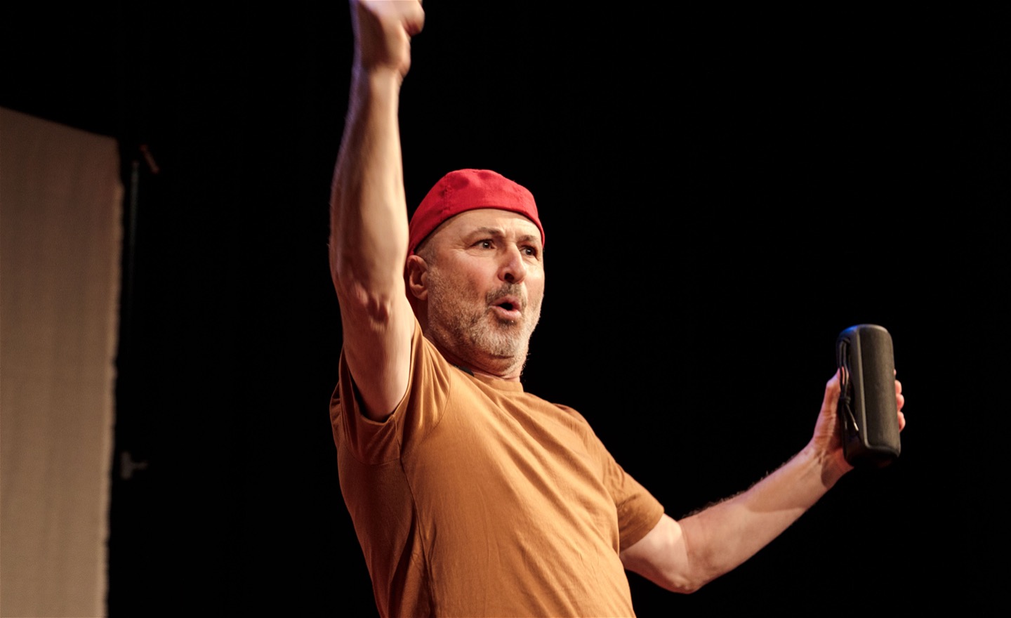 Fikret med röd keps och högtalare i handen.