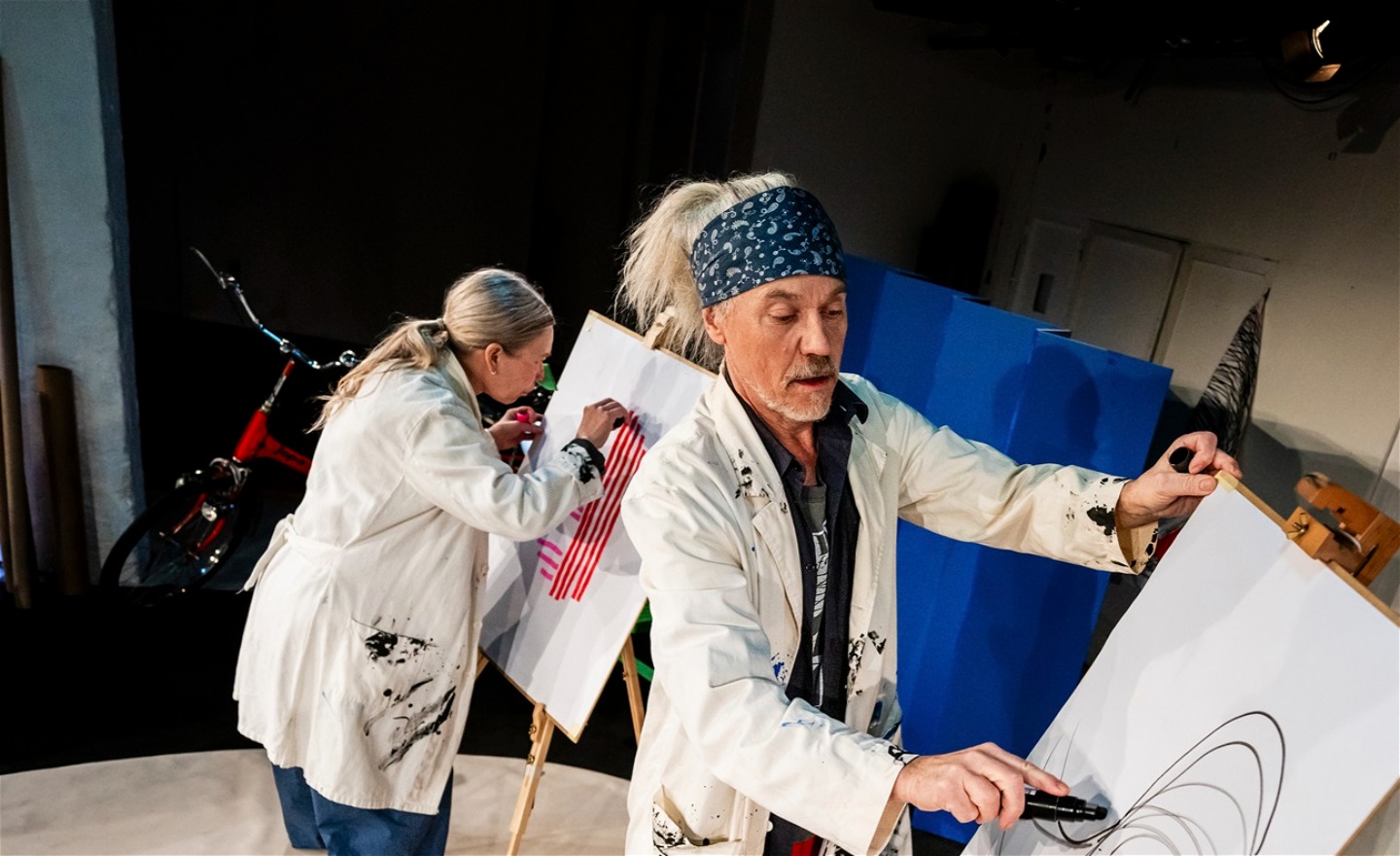 Två dansare målar varsin tavla