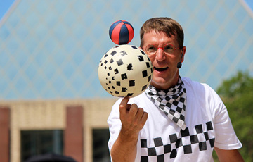 En man balanserar två bollar på pekfingret.