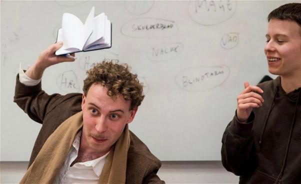 En man visar upp en skrivbok.