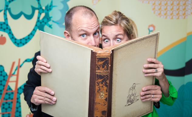 Två personer läser i en bok