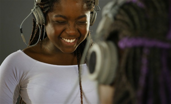 En flicka med hörlurar som skrattar