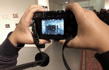 Två händer som håller i en kamera där displayen syns.