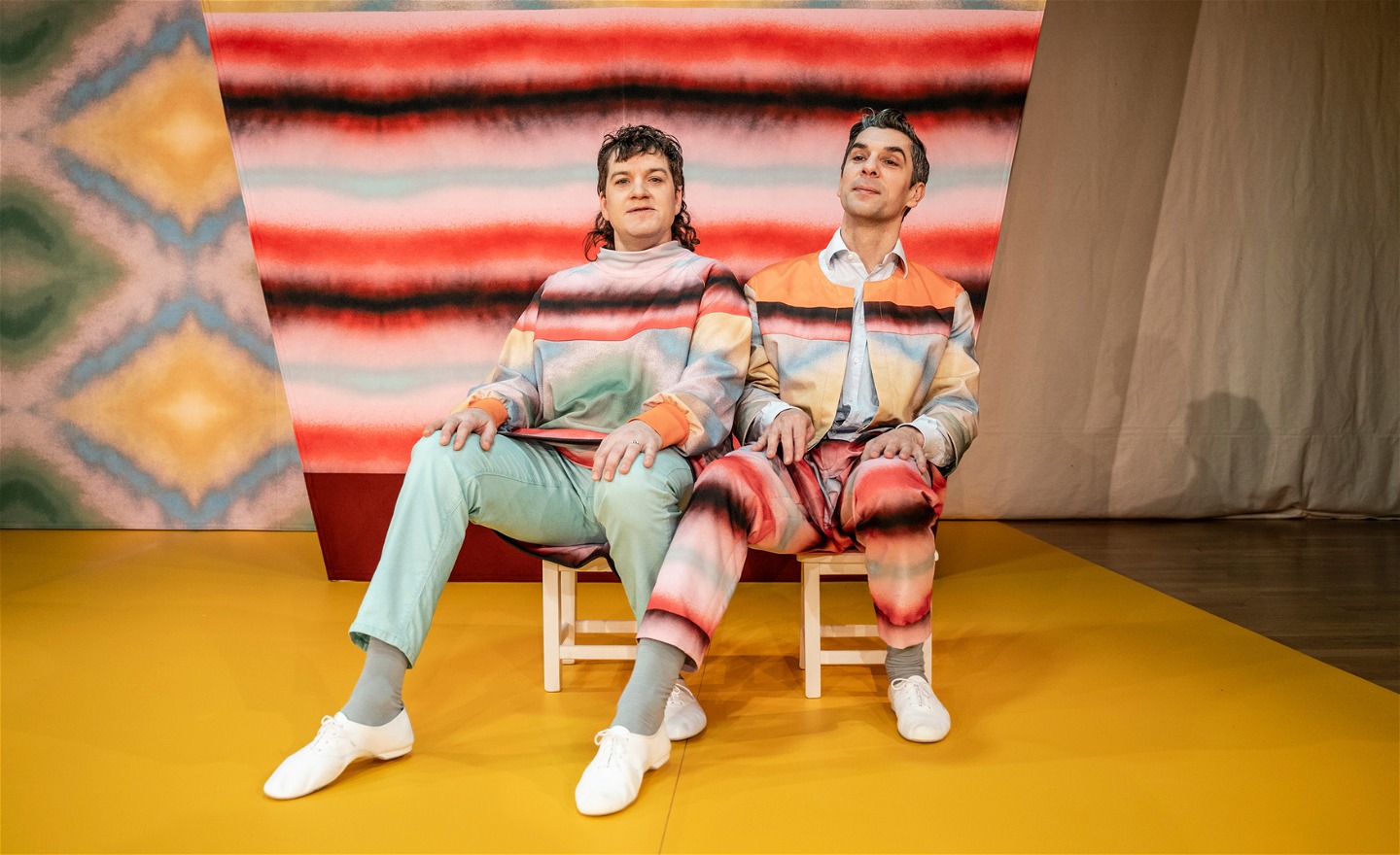 Niklas och Martin sitter på en varsin pall med utsträckta fötter. 