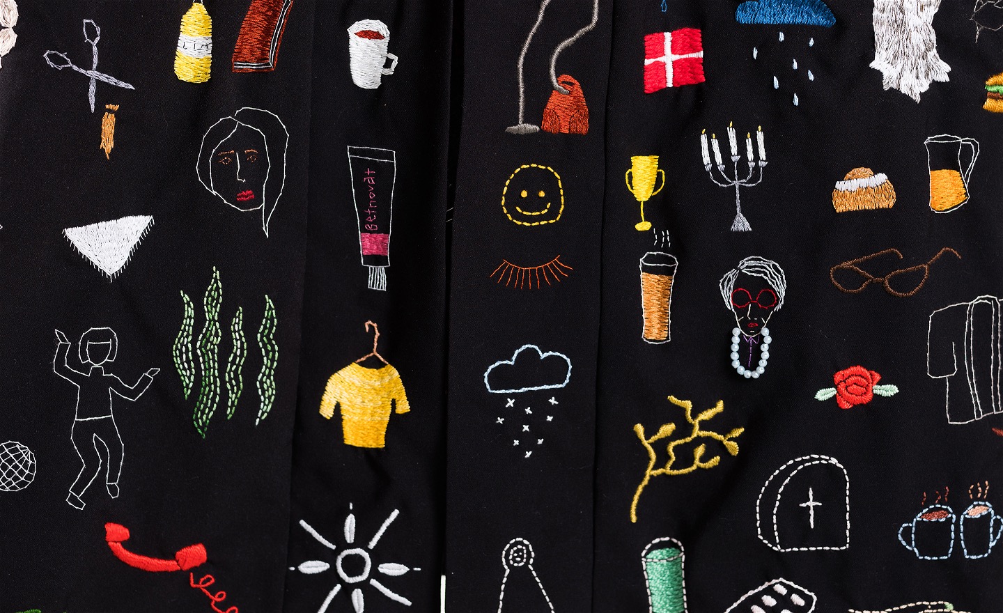 En bild av små broderade symboler på svart bakgrund