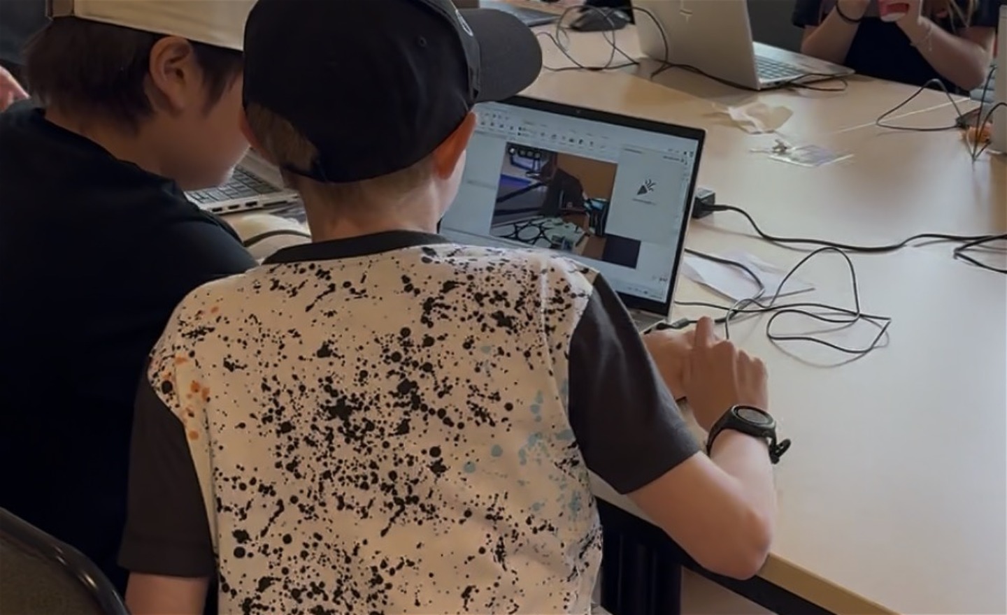 Två elever bygger egna spel i Roblox Studio på laptop under en Floating Code-workshop.
