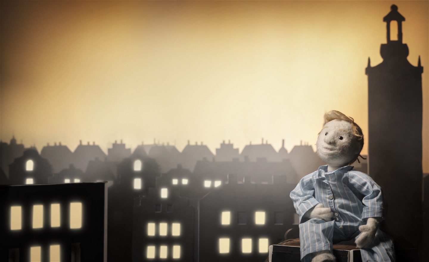 Göran sitter på ett hustak och blickar upp mot himlen med Stockholms hustak som silhuett bakom. Foto: Markus Gårder