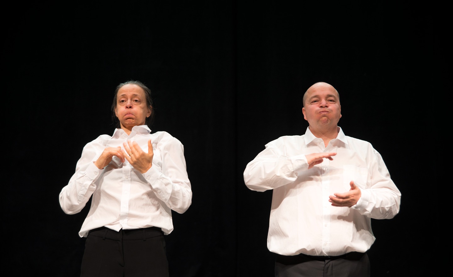 Bild på två dansare i vita skjortor från föreställningen Astrid. 