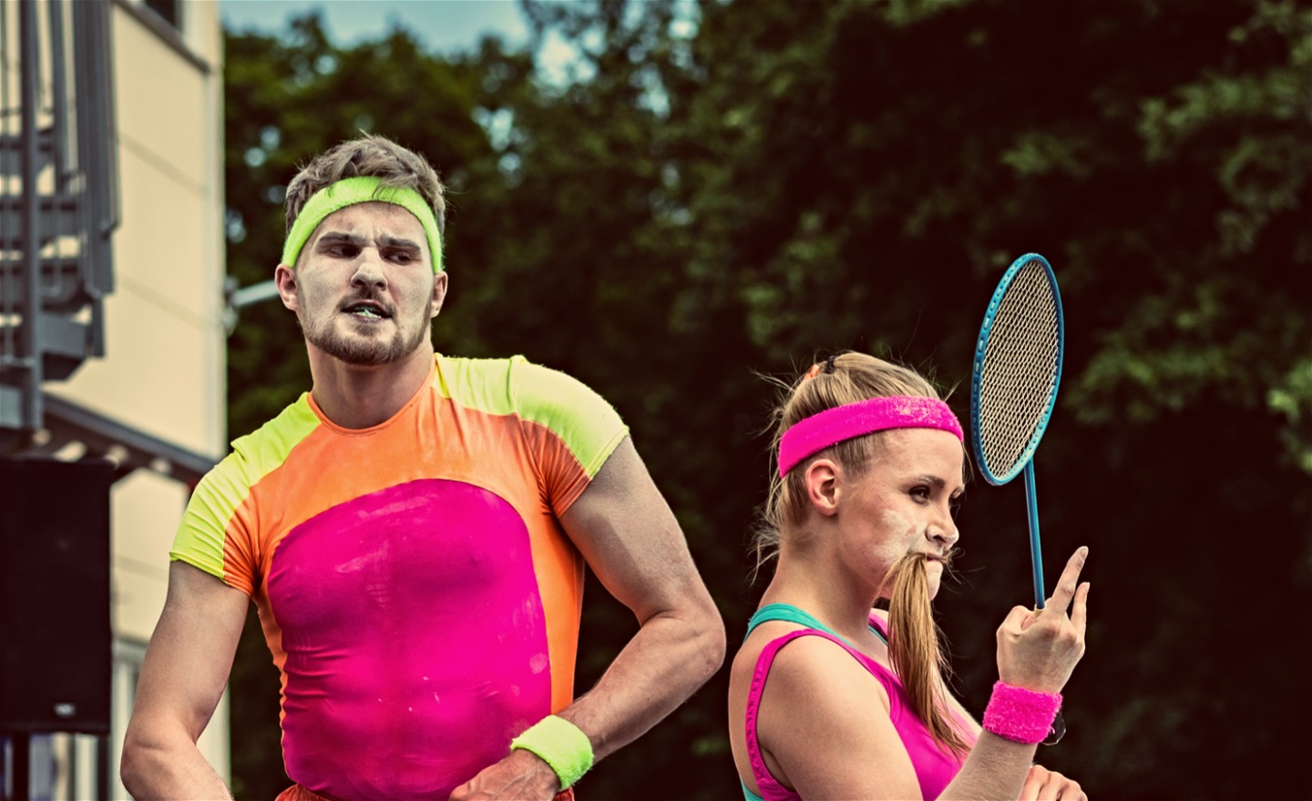 Två cirkusartister i färgglada kläder.