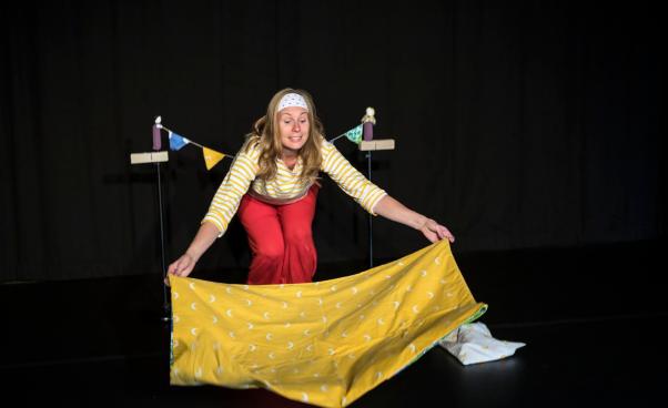 Micaela breder ut en gul filt med månar på