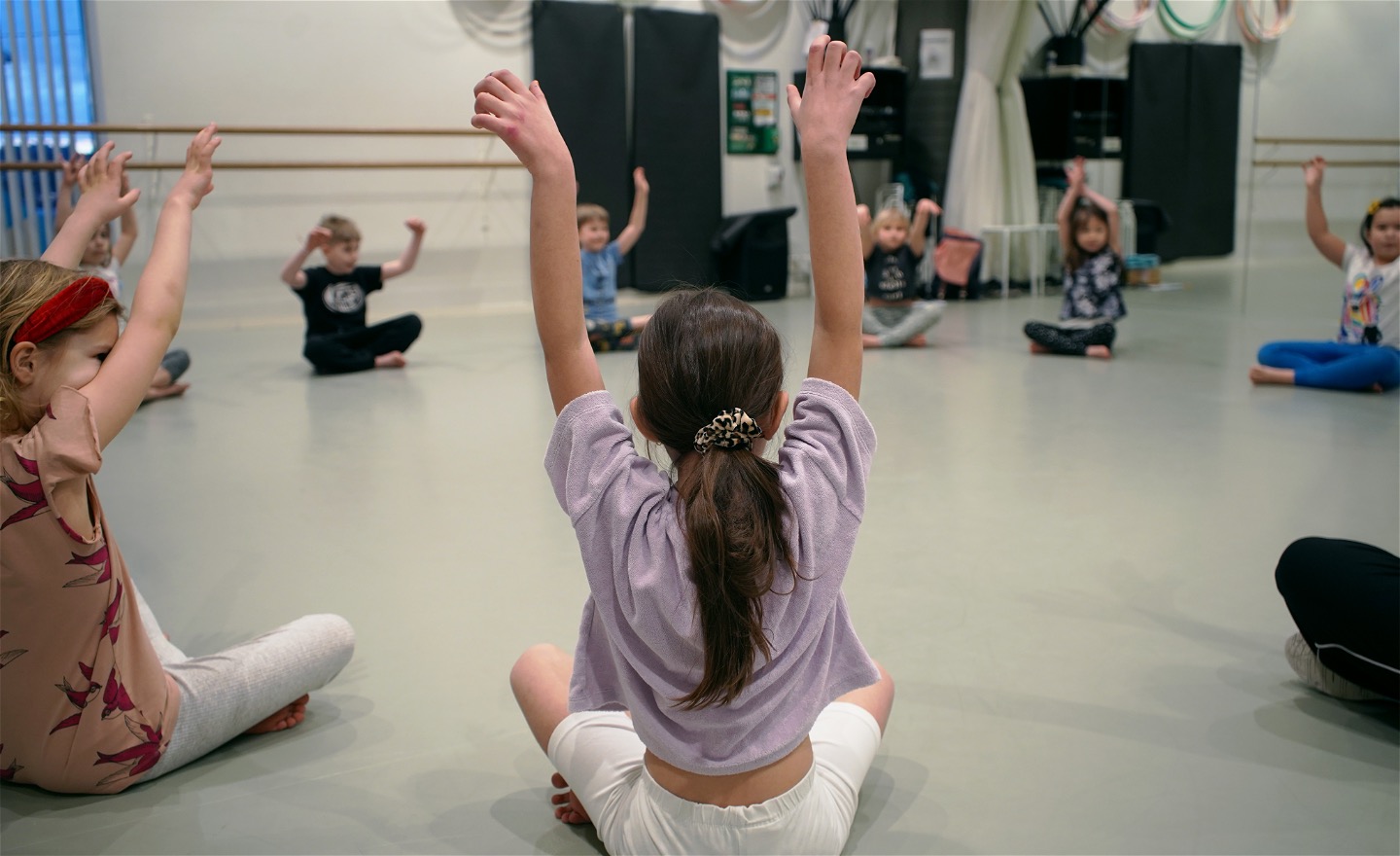 Barn sittande i cirkel i danssal
