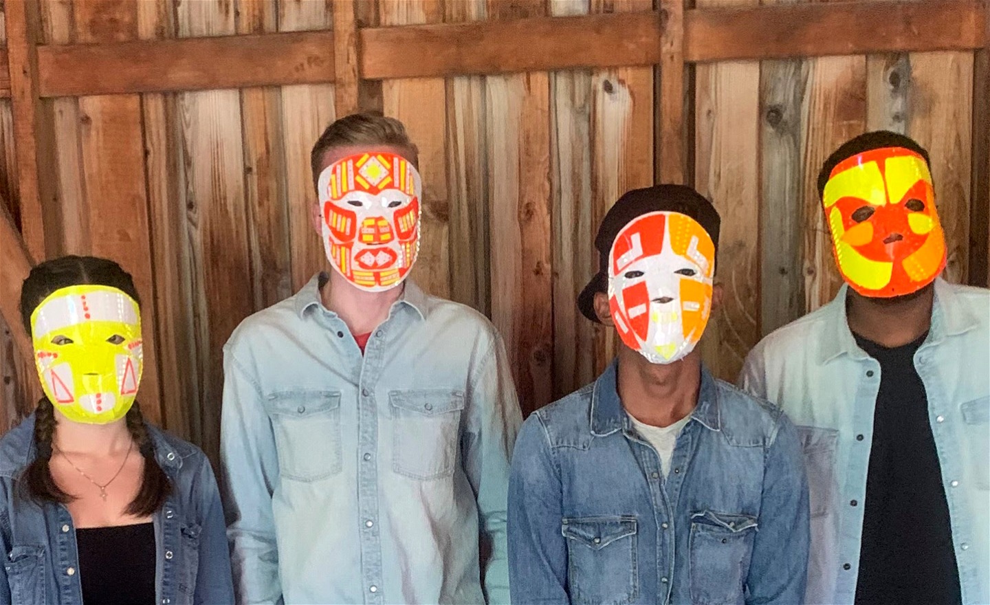 Fyra ungdomar med masker som de har skapat av reflex folie (återbruk material).