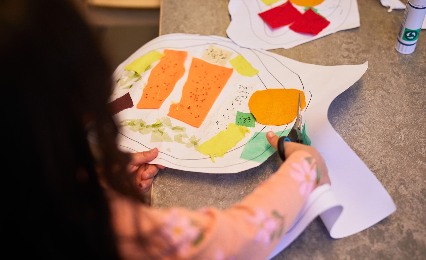 Ett barn klipper papper under en workshop.