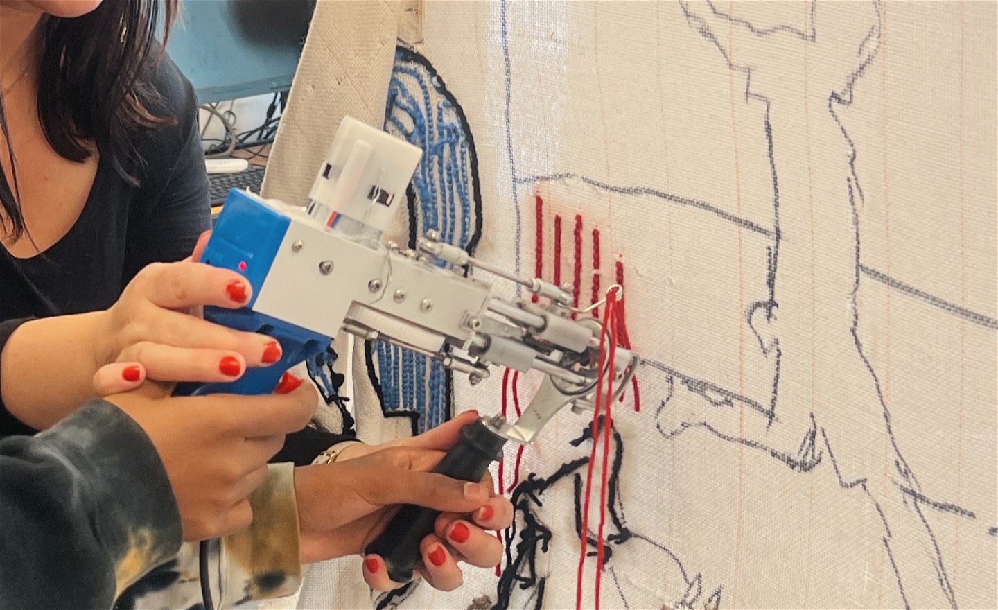 Motiven ritas upp på duken, tuftningspistolen trär man garnet i