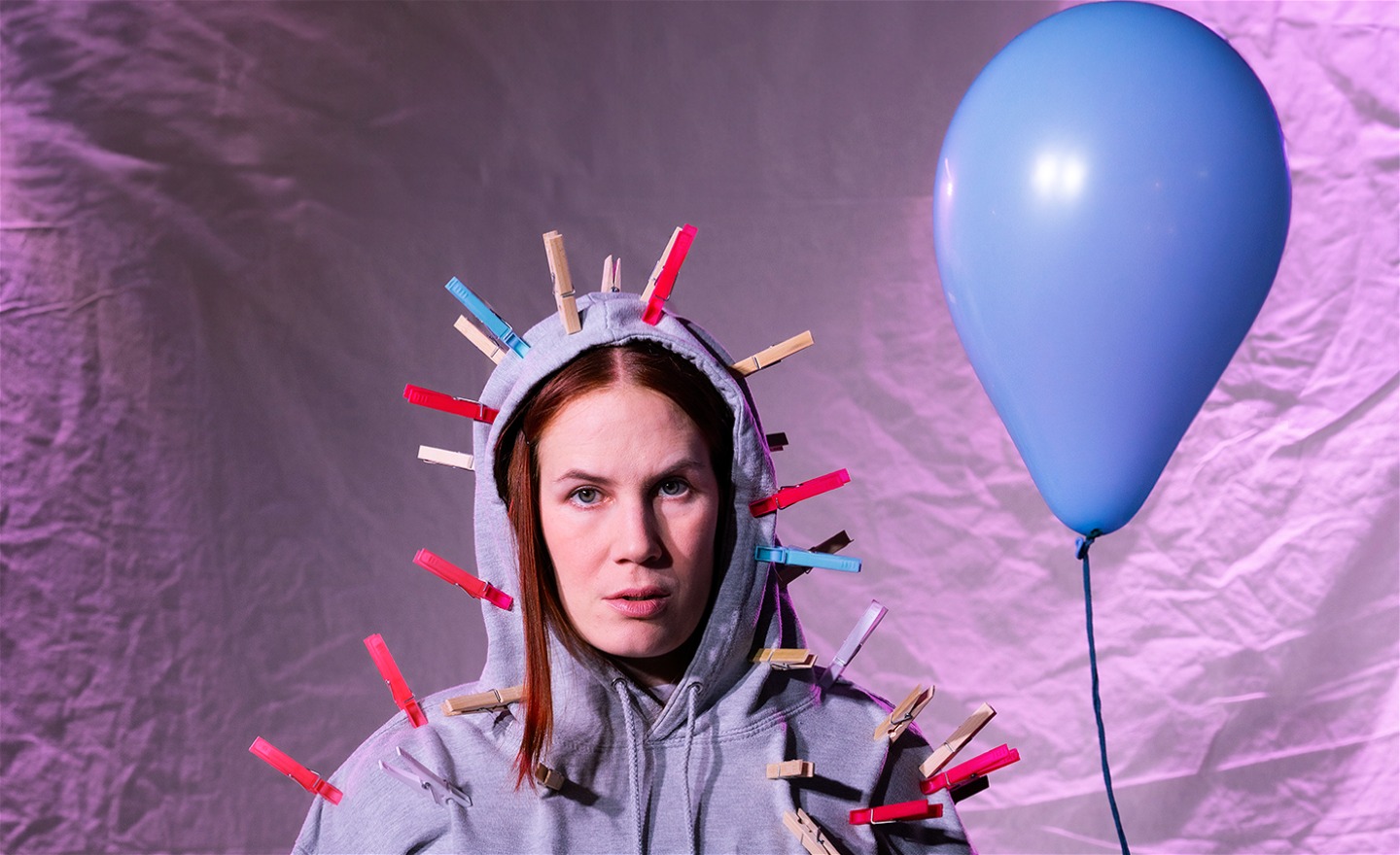 En flicka med klädnypor kring ansiktet.