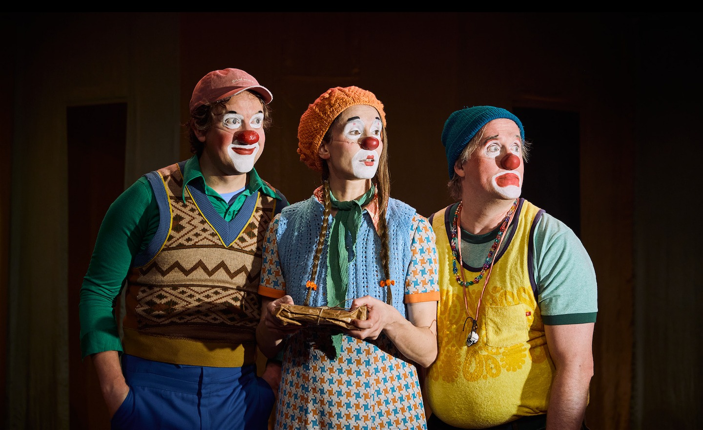 Tre clowner tittar ut åt höger