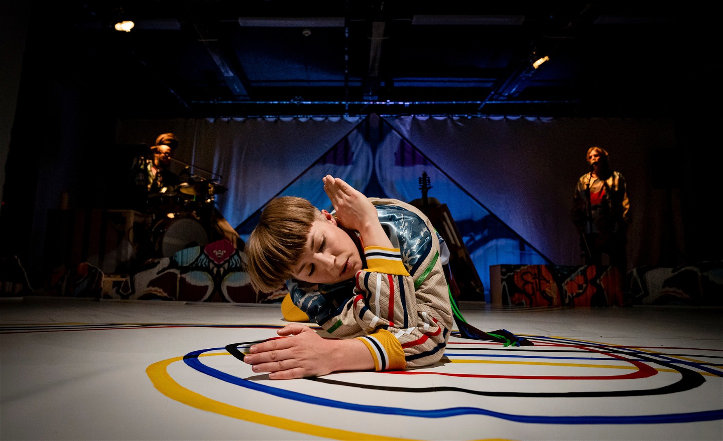 Dansare med  sammanflätade armar ligger på golvet. 