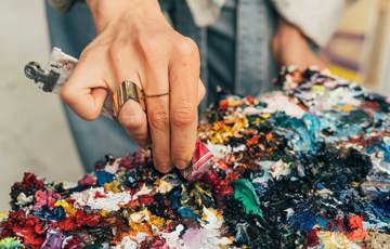 En person trycker ut färg på en färgpalett.