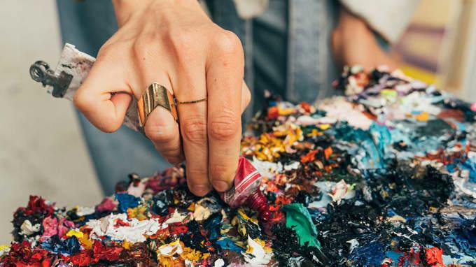 En person trycker ut färg på en färgpalett.