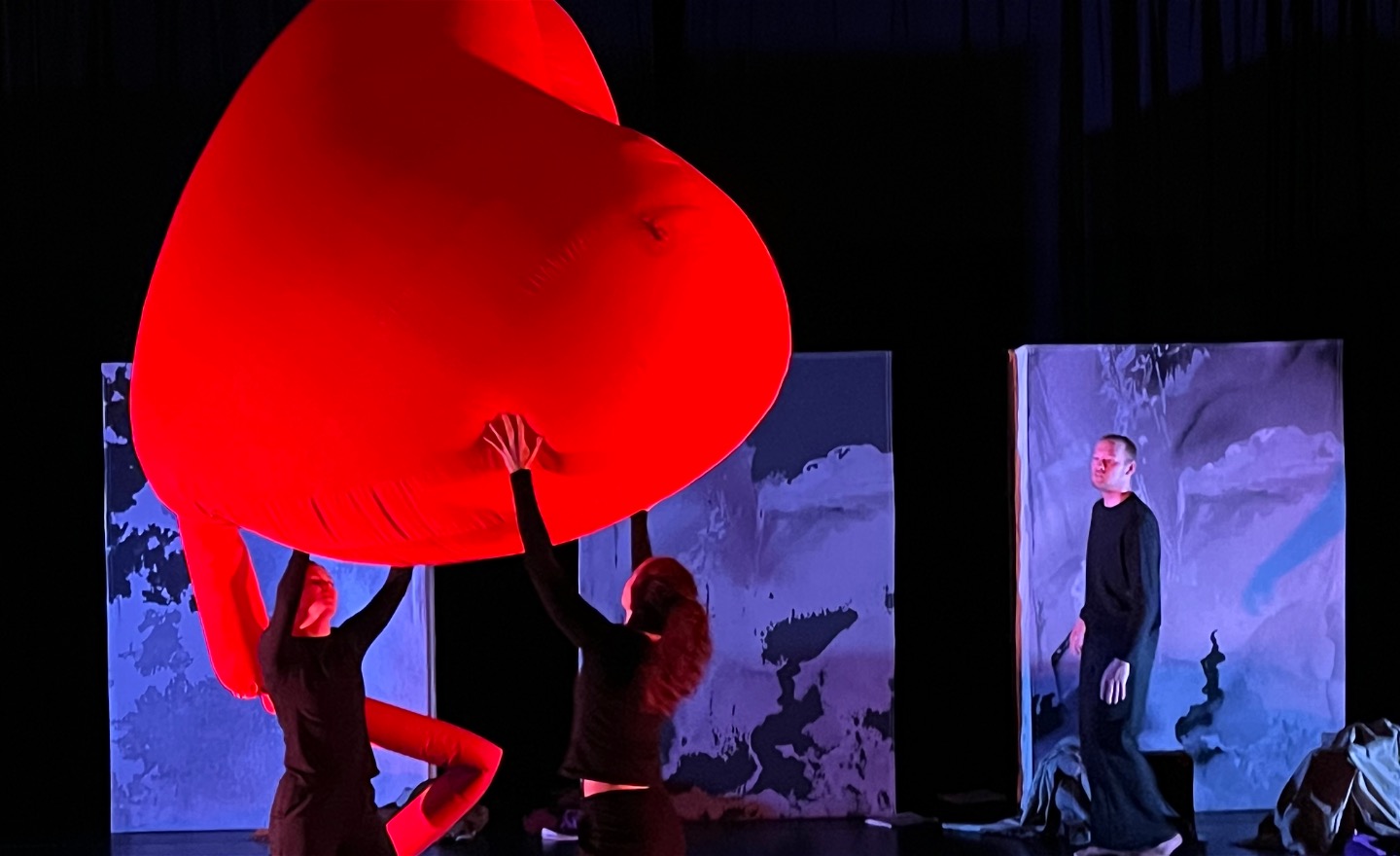 två dansare i svarta kläder håller i ett 2 m stort hjärta