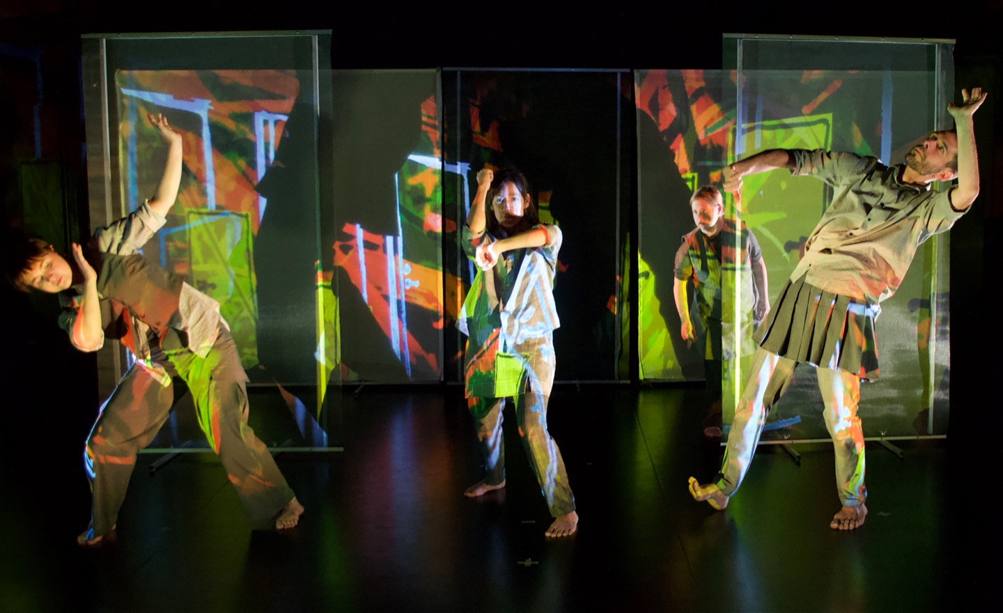 En arg dansare och tre andra aktar sig i en röd miljö av gula dörrar.